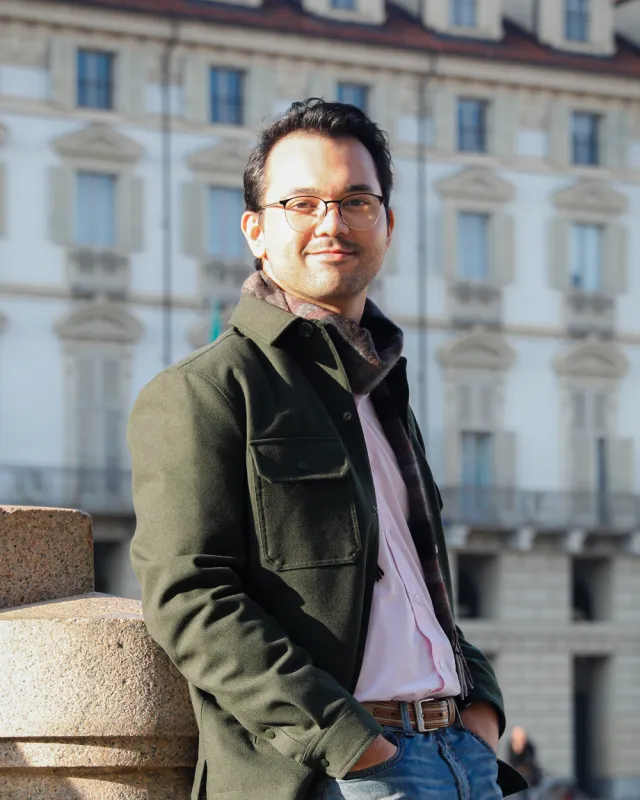 Tristan Eason leaning against a granite plinth in a piazza in Turin